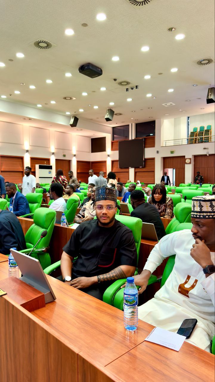 Harrison at formal conference hall with attendees